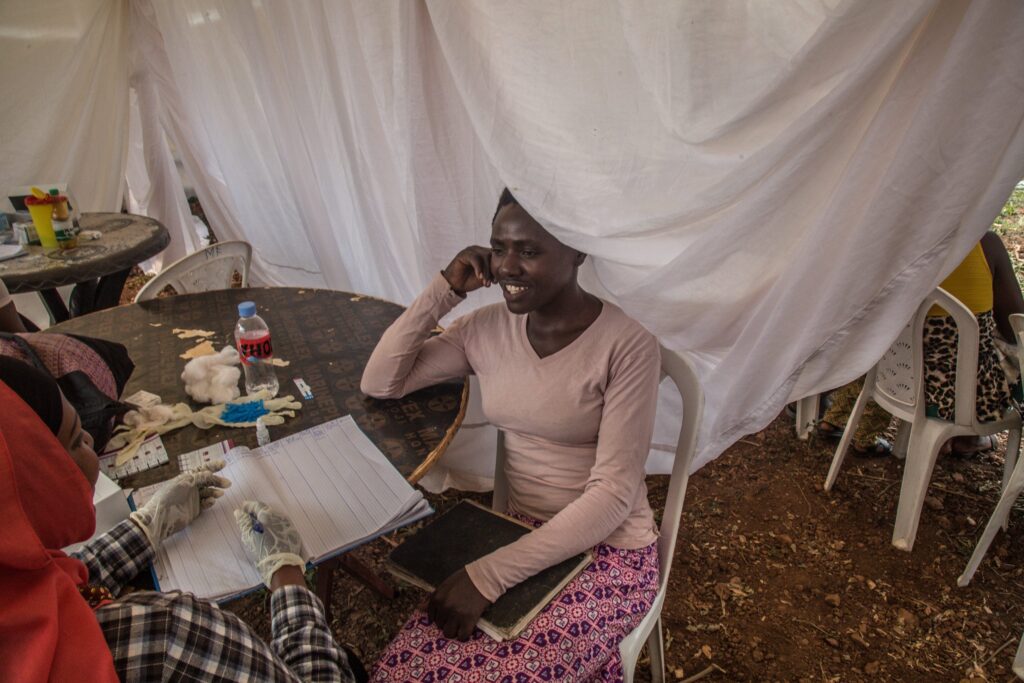 Woman discusses with a medical professional at a table.